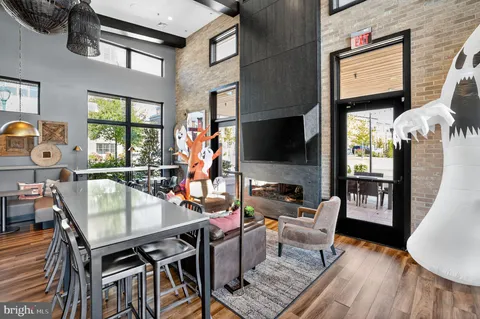 a living room with furniture a flat screen tv and a floor to ceiling window