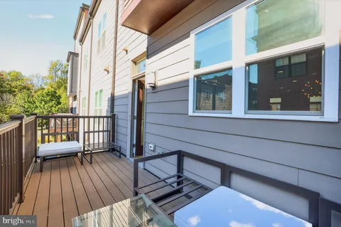a view of a balcony with wooden floor and iron fence