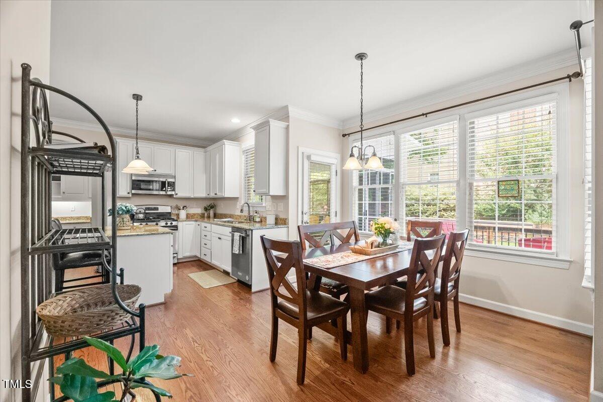 102 Barometer Lane Cary, NC 27513 - Photo 11 of 44 a dining room with furniture a chandelier and wooden floor