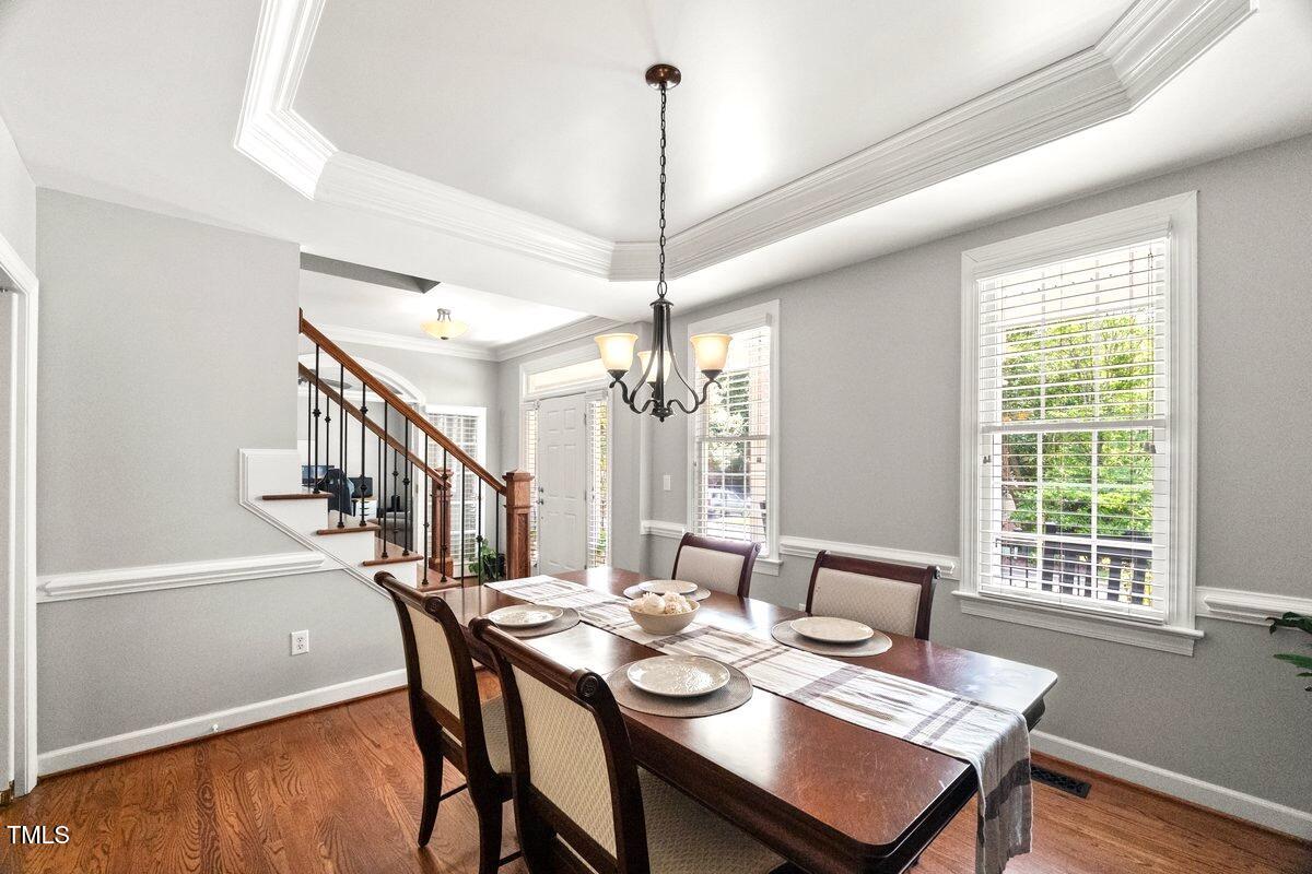 102 Barometer Lane Cary, NC 27513 - Photo 7 of 44 a dining room with furniture a chandelier and wooden floor