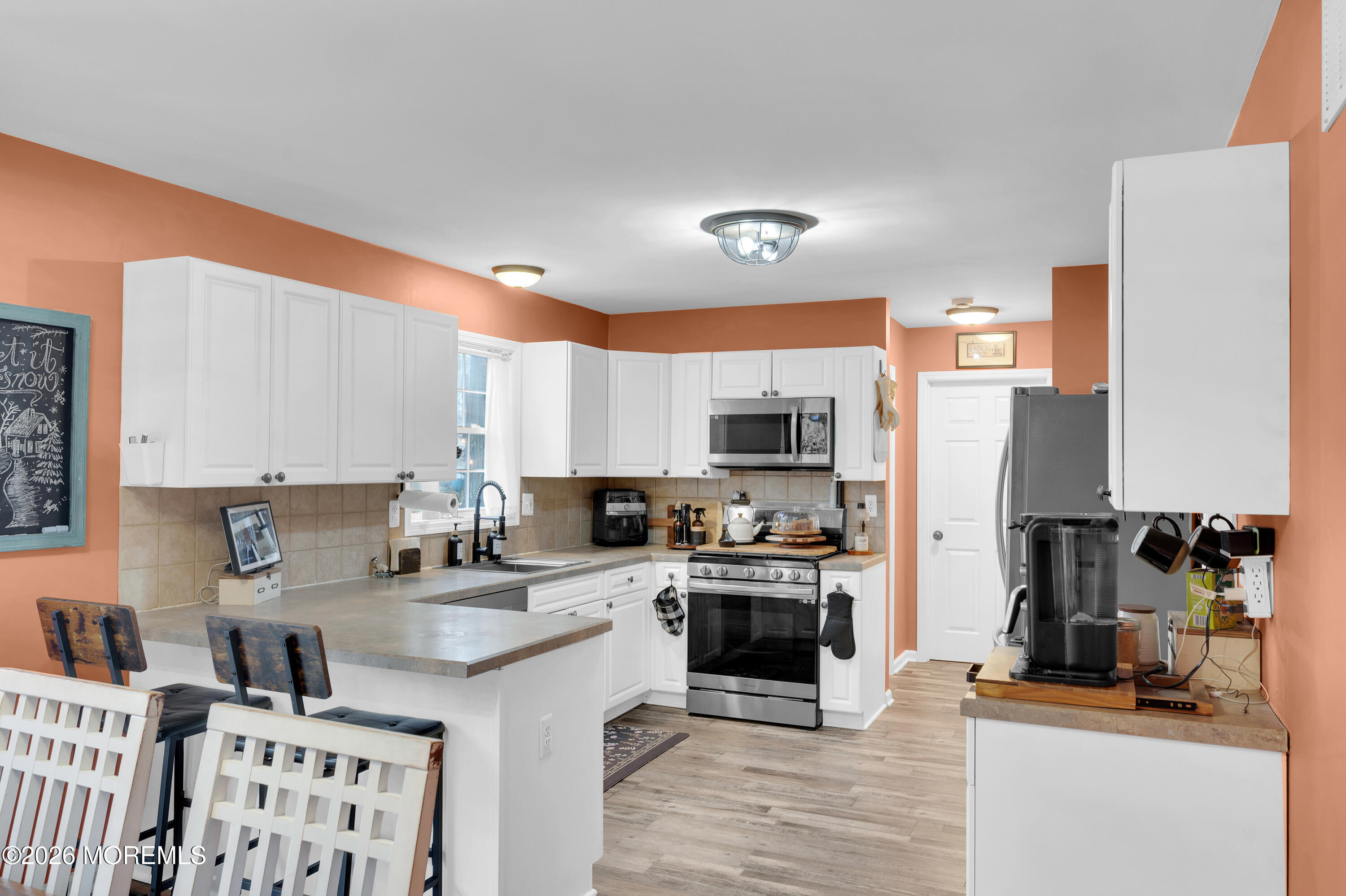321 Letts Avenue Forked River, NJ 08731 - Photo 35 of 38 a kitchen with stainless steel appliances a stove a sink a refrigerator cabinets and a dining table