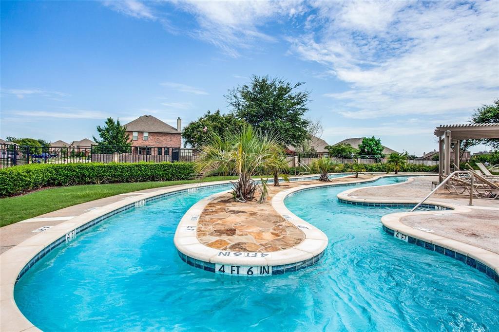 5817 Deck House Road Fort Worth, TX 76179 - Photo 18 of 19 Winding leisure pool featuring a tiled edge, integrated islands with palm plantings, surrounding stone-finish decking, and an adjacent shaded pergola