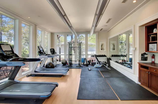 a room with lots of tables a large window and furniture