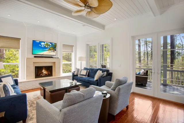 a living room with furniture a fireplace and a large window