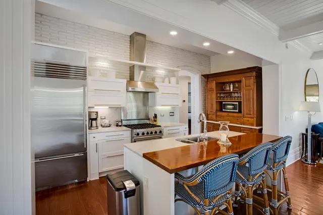 a kitchen with stainless steel appliances granite countertop a sink a stove and a refrigerator