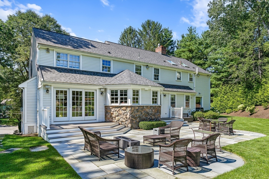 169 Hampshire Road Wellesley, MA 02481 - Photo 37 of 42 a view of a patio with table and chairs potted plants and a large tree