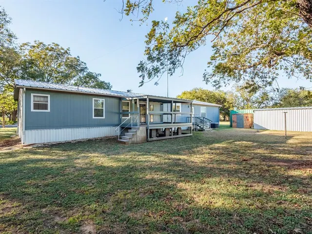 a view of dirt yard with large trees