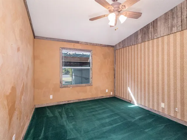 en empty room with window and ceiling fan