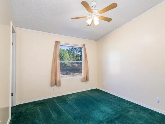 an empty room with a window and a fan