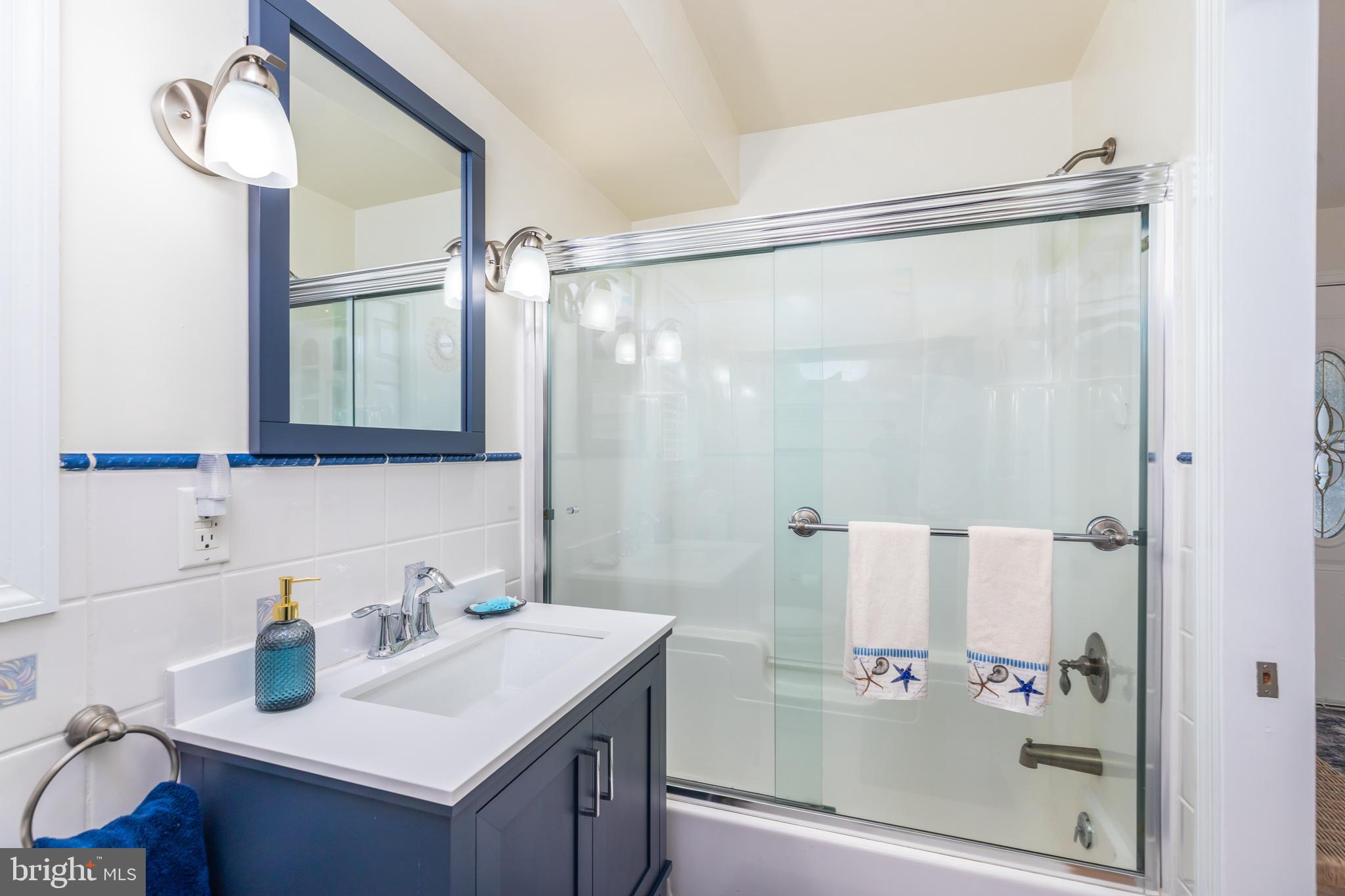 28016 Possum Point Road Millsboro, DE 19966 - Photo 12 of 70 a bathroom with a sink mirror and shower