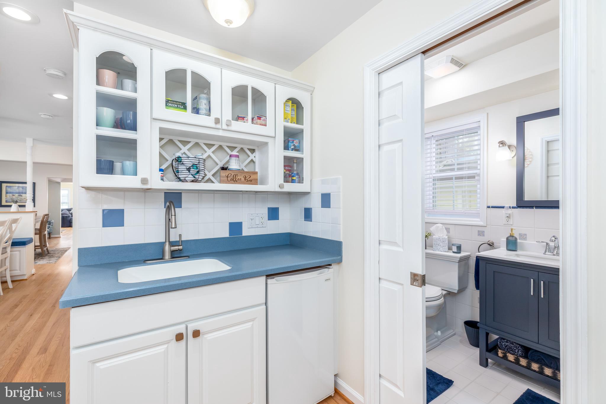 28016 Possum Point Road Millsboro, DE 19966 - Photo 14 of 70 a kitchen with a sink dishwasher a dining table and chairs with wooden floor