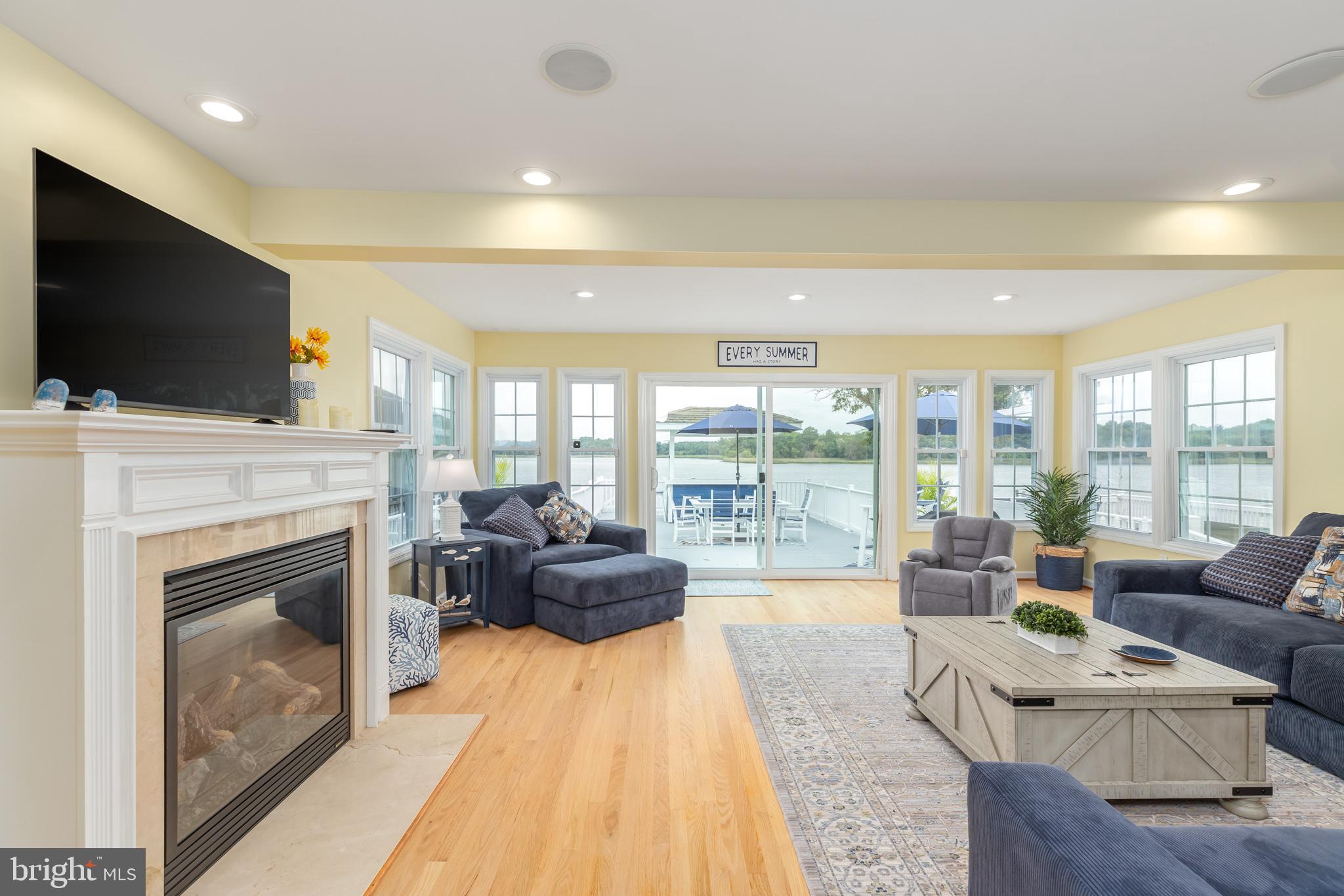 28016 Possum Point Road Millsboro, DE 19966 - Photo 24 of 70 a living room with furniture a flat screen tv and a fireplace