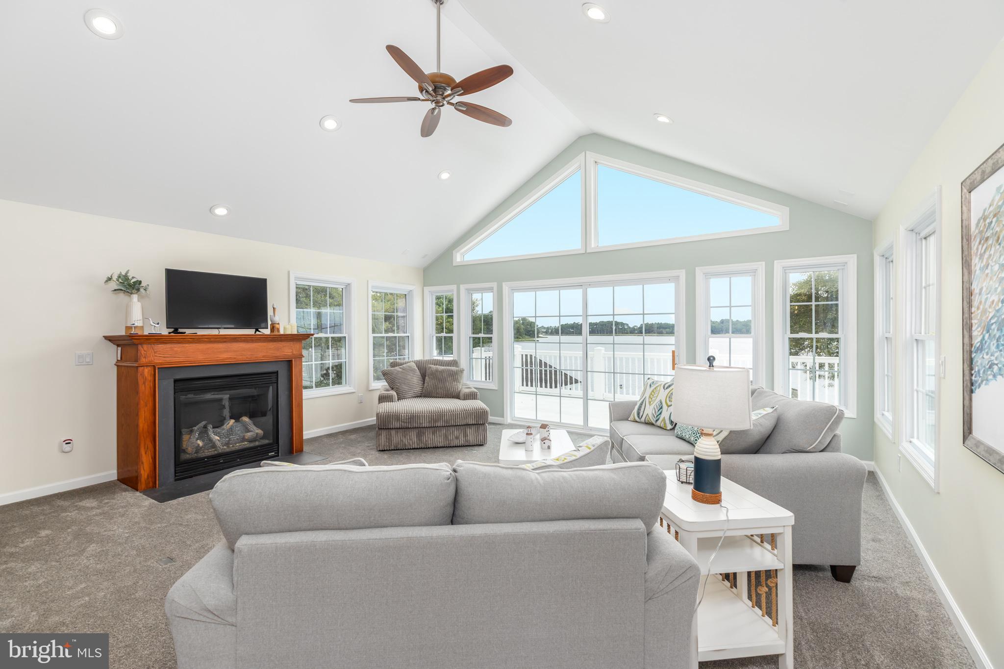 28016 Possum Point Road Millsboro, DE 19966 - Photo 28 of 70 a living room with furniture a fireplace and a flat screen tv