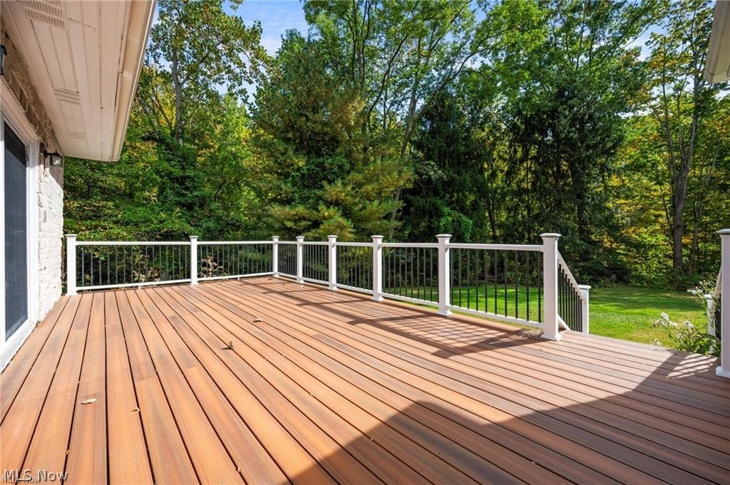 28300 Aurora Road Solon, OH 44139 - Photo 34 of 36 Expansive outdoor deck featuring wood-finish decking, white railings with black balusters, and direct access to a grassy yard