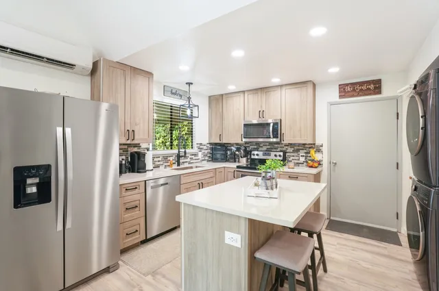 a kitchen with refrigerator a sink and chairs
