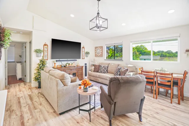 a living room with furniture a large window and a flat screen tv