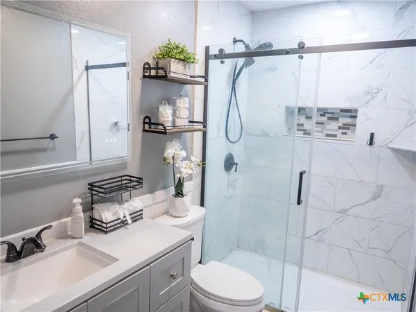 a bathroom with a sink a toilet and shower