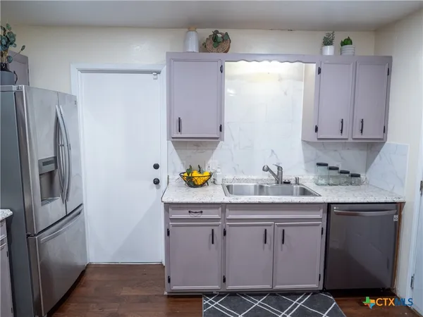 a kitchen with stainless steel appliances granite countertop a refrigerator and a stove