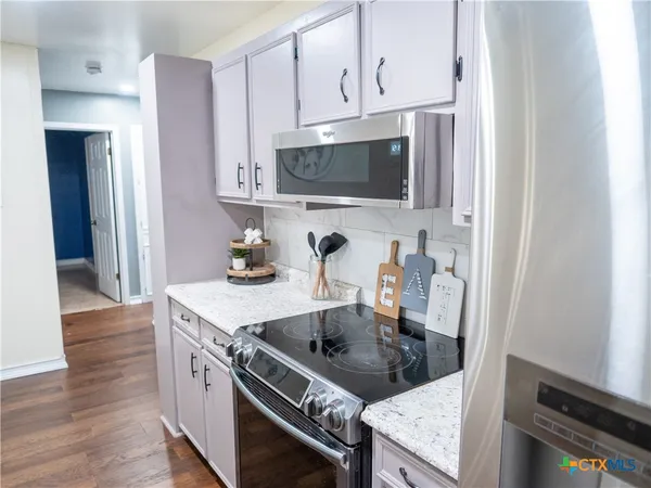 a kitchen with stainless steel appliances granite countertop a stove and a microwave
