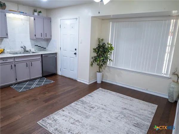 a view of a kitchen with wooden floor and a window