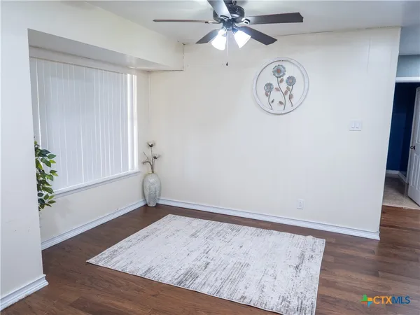 an empty room with a window and a fan