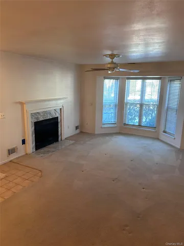 an empty room with windows and fireplace