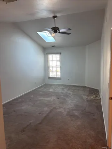 an empty room with a window and a ceiling fan