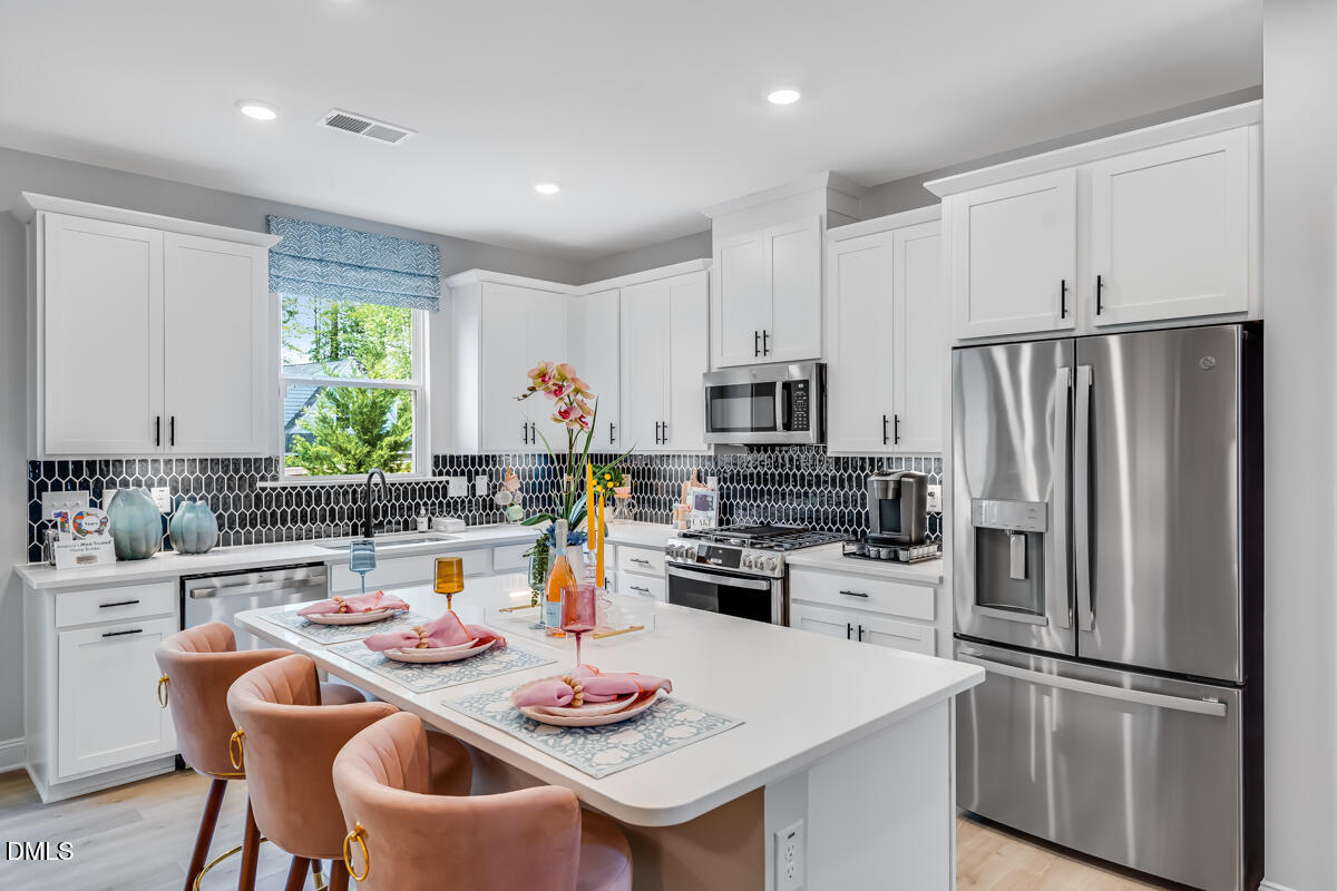 8767 Wardle Court Wake Forest, NC 27587 - Photo 9 of 32 a kitchen with refrigerator and white table