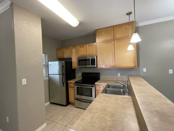 a kitchen with granite countertop a refrigerator and a sink