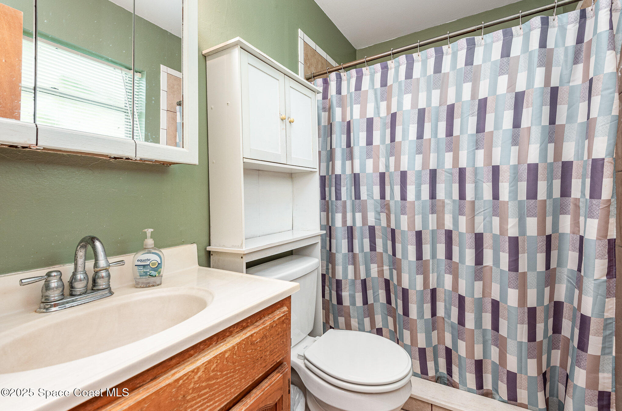 5930 Ackard Avenue Cocoa, FL 32927 - Photo 18 of 22 a bathroom with a sink a toilet and shower curtain