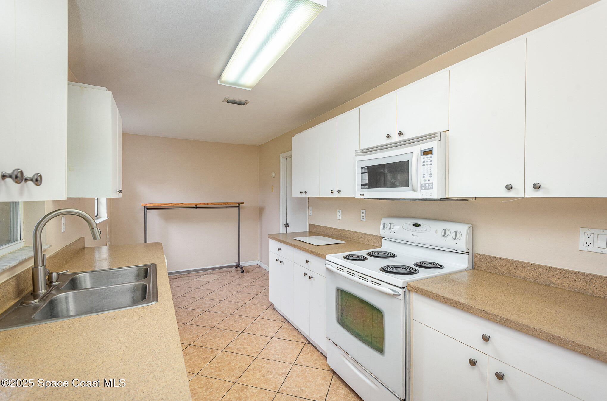 5930 Ackard Avenue Cocoa, FL 32927 - Photo 7 of 22 a kitchen with granite countertop a stove a sink and a microwave