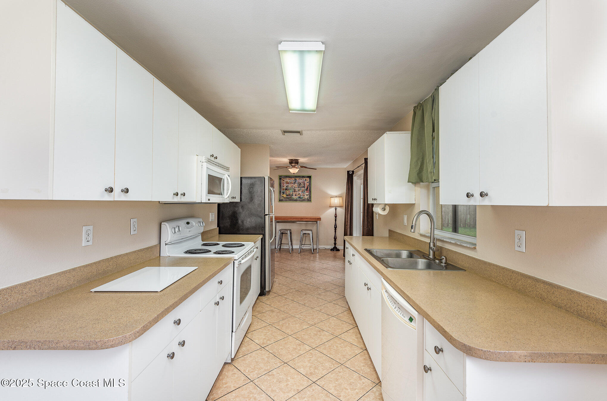 5930 Ackard Avenue Cocoa, FL 32927 - Photo 9 of 22 a large white kitchen with stainless steel appliances granite countertop a sink and cabinets
