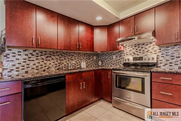 a kitchen with granite countertop wooden cabinets and stainless steel appliances
