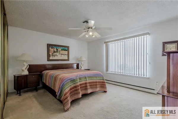 a spacious bedroom with a bed and a chandelier