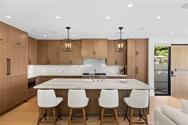 a kitchen with stainless steel appliances granite countertop a table and chairs in it