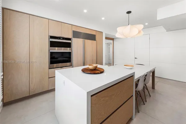 a kitchen with stainless steel appliances a table and chairs