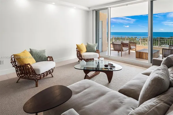 a living room with furniture and a floor to ceiling window
