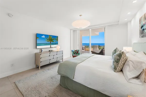 a bedroom with bed a tv and a window