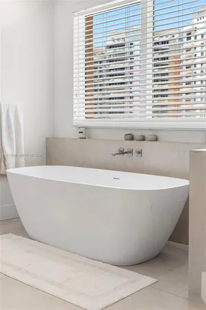 a white bath tub sitting in a bathroom next to a window