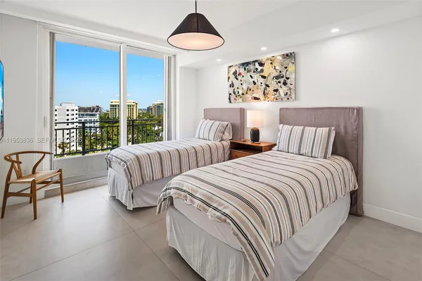 a bedroom with two beds and a large window
