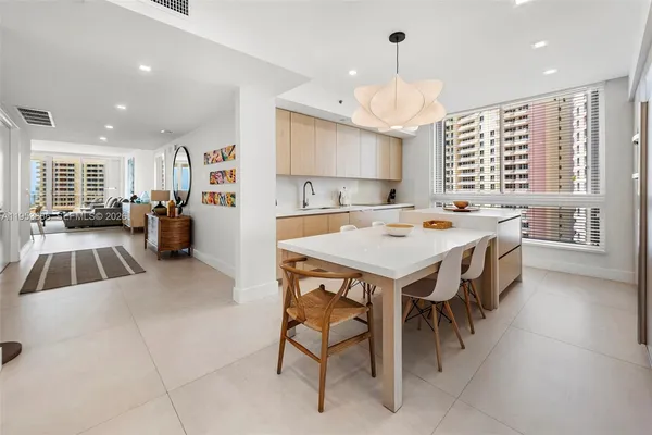 a kitchen with a stove a refrigerator and a dining table with wooden floor