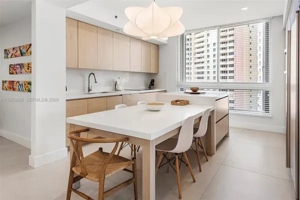 a kitchen that has a stove a sink and a dining table in it