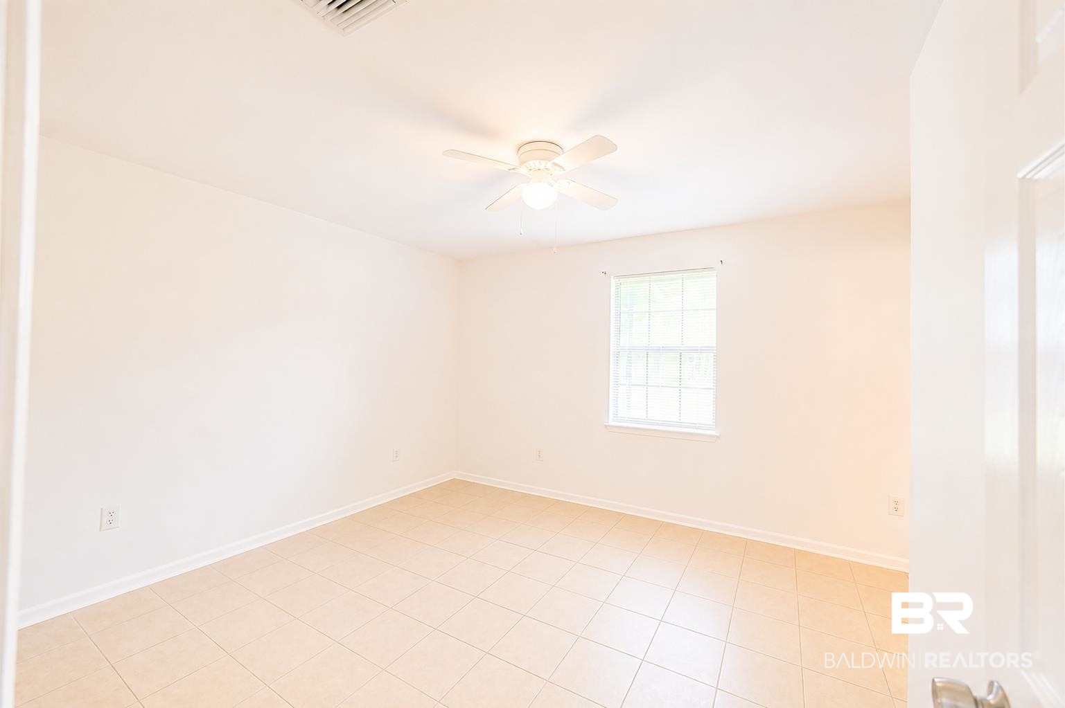 614 East Gate Circle Foley, AL 36535 - Photo 20 of 31 Spacious room featuring neutral-toned tile flooring, a single window with grids, and a ceiling fan with integrated lighting