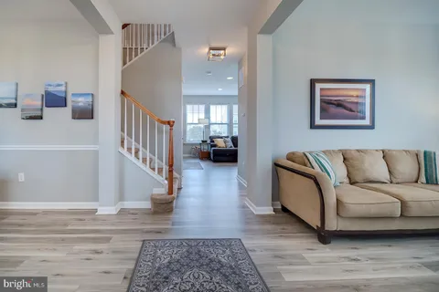 a view of a dining room with furniture a chandelier and wooden floor