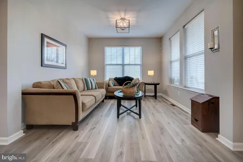 a dining room with wooden floor a chandelier a glass table and chairs
