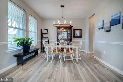 a view of a hallway with wooden floor and a bathroom