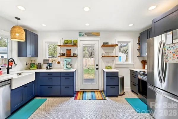 a large kitchen with stainless steel appliances granite countertop a refrigerator and a stove top oven