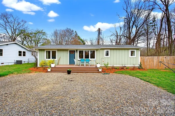 a view of a house with a yard and large tree