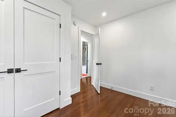 an empty room with wooden floor and a entrance