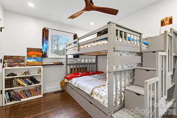 a bedroom with bed and a book shelf